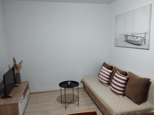 uma sala de estar com um sofá e uma mesa em Apartments Mijo em Kaštela