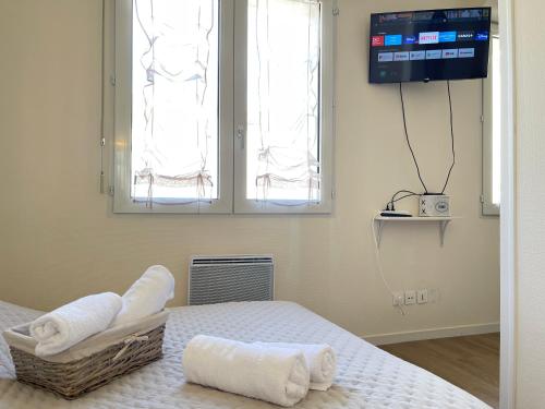 a room with a bed with towels on it at Le Sablier - Centre ville - 15 min du Futuroscope in Poitiers