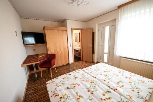 a hotel room with a bed and a desk and a computer at Gästehaus zum See in Illmitz