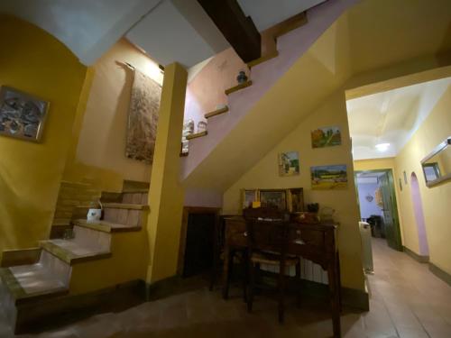 uma sala de estar com paredes amarelas e escadas e uma mesa em Casa Rural el Zapatero 