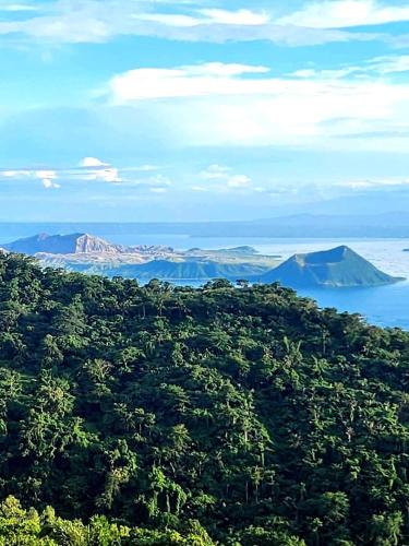 an island in the ocean with mountains in the distance at Sang Yoo Mountain View Tagaytay Bed and Breakfast - Taal Lake View in Tagaytay