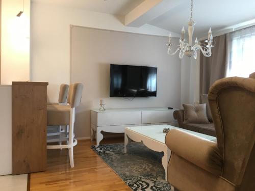 a living room with a couch and a tv at cream apartment in Banja Luka