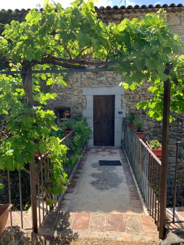 a door in a stone building with a fence at LE FLEURISTE in Saint-Sauveur-de-Cruzières