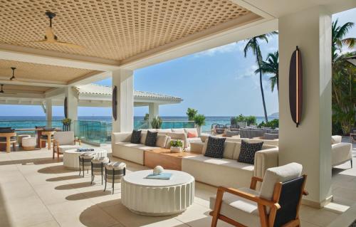 - une terrasse avec des canapés et des tables donnant sur l'océan dans l'établissement Morningstar Buoy Haus Beach Resort at Frenchman's Reef, Autograph Collection, à Nazareth