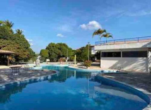 uma piscina com água azul e um edifício em Chalé Refidim em Gravatá