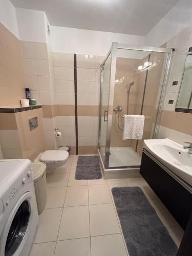a bathroom with a shower and a washing machine at Levilena apartament Osiedle Bałtyk in Grzybowo