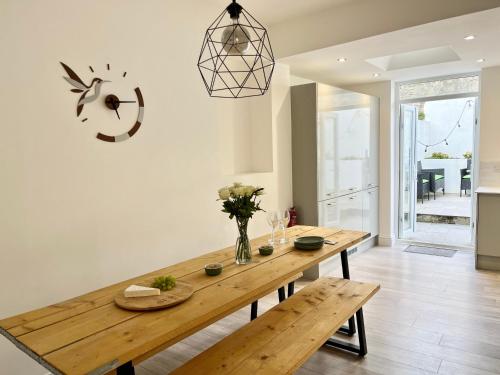 a dining room with a wooden table and a clock at Saltwater Pearl - A charming 4 bed townhouse in Ilfracombe