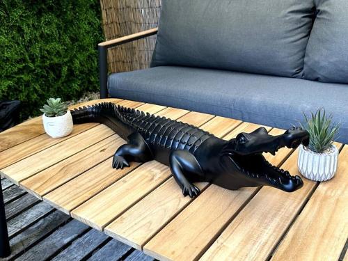 蓋亞的住宿－Geneva Jungle Loft，坐在沙发旁桌子上的黑色鳄鱼雕像