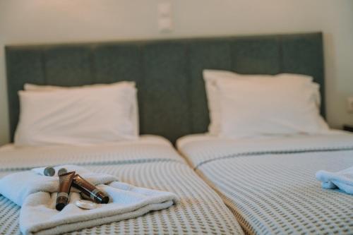 two beds with towels and a cross on them at Karavostasi Beach Hotel in Perdika