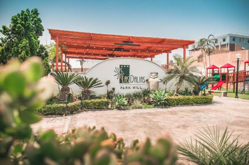 a building with a sign in front of it at Hotel Las Dalias in Huaral