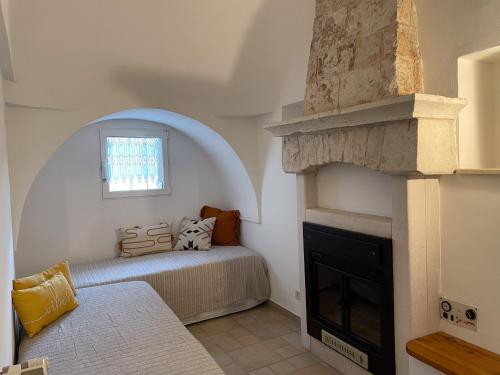 ein Schlafzimmer mit einem Bett und einem Kamin in der Unterkunft Trullo vacanze di Cummà Rosa in Alberobello