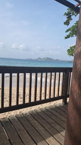 a view of the beach from a deck at Studio cosy les pieds dans l'eau à l'autre bord in Le Moule