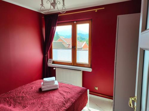 a red bedroom with a bed and a window at Apartament Centrum in Ustroń