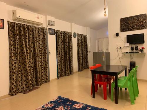 a dining room with a table and green chairs at Chalet Ahaz, the place of privacy with outside sitting in Karjat