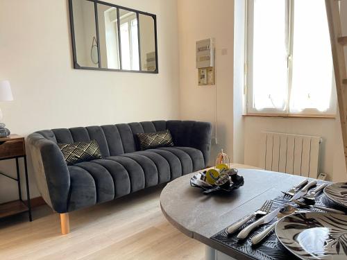 uma sala de estar com um sofá e uma mesa em Pont Achard #2-T1bis-Mezzanine -5mnGare- Poitiers em Poitiers