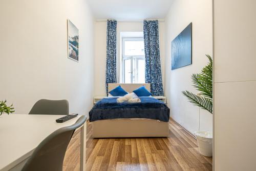 um pequeno quarto com uma cama e uma secretária em Modern Comforts: Chic Studio Apt Centrally Located em Viena