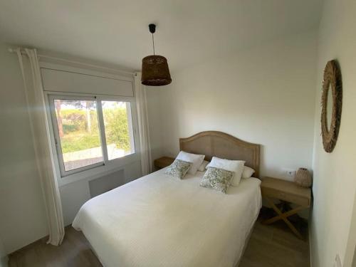 a bedroom with a white bed and a window at Fantastica casa con piscina a 5 min a pie del mar - Sorramar in Gavà