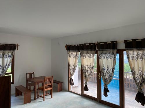 um quarto com cortinas, uma mesa e uma janela em Blue Villa Zanzibar em Pwani Mchangani