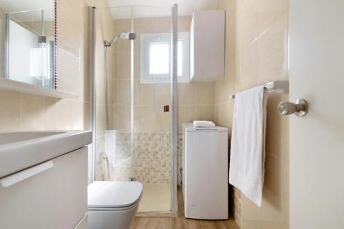ein weißes Bad mit einem WC und einer Dusche in der Unterkunft Be Room Oasis Cozy Duplex in Maspalomas