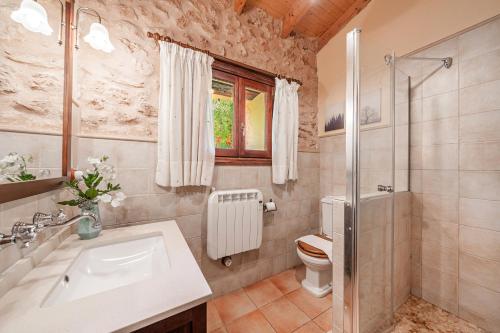 uma casa de banho com um lavatório e um WC em Sa Sort em Alaró
