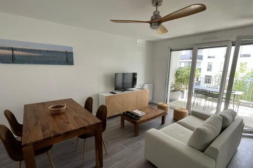 a living room with a couch and a table at Appartement cosy 80m2 au pied du tram de Bordeaux in Eysines