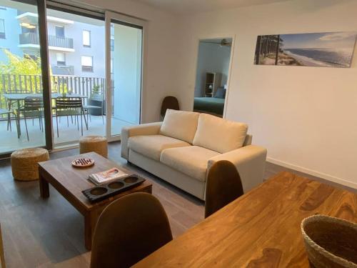 - un salon avec un canapé et une table dans l'établissement Appartement cosy 80m2 au pied du tram de Bordeaux, à Eysines