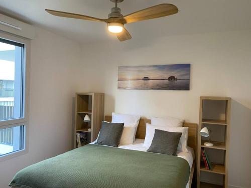 - une chambre avec un lit et un ventilateur de plafond dans l'établissement Appartement cosy 80m2 au pied du tram de Bordeaux, à Eysines