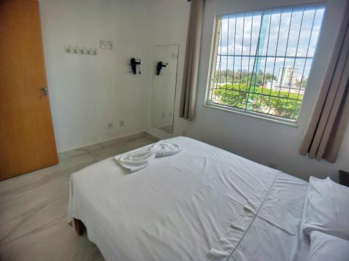 Habitación hospital con cama blanca y ventana en Casa confortável e segura na região da Pampulha en Belo Horizonte