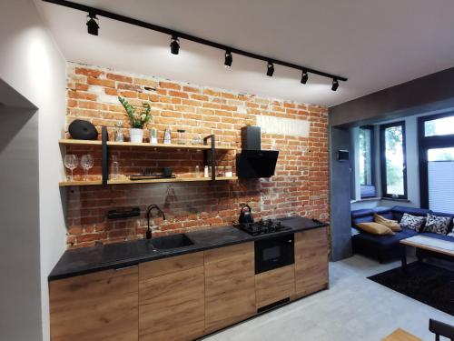 een keuken met een bakstenen muur en een wastafel bij Apartament nr 2 w Starym Nadleśnictwie in Kościerzyna