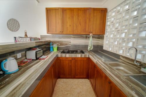 una cocina con armarios de madera y fregadero en Titian Dewi Villa Ubud - 3 Bedroom Private Villa Close to Cretya Day Club en Tegalalang