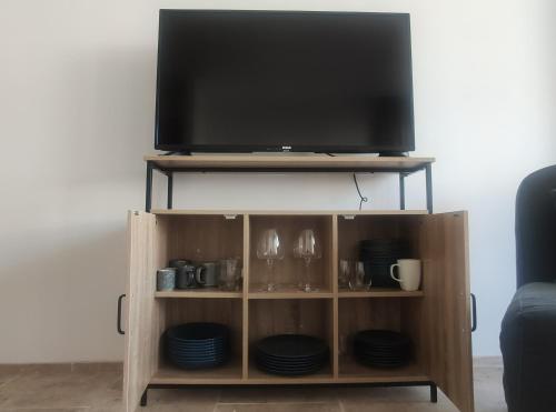a flat screen tv on top of a wooden entertainment center at A-Ventoux Malaucène - Au pied du Ventoux in Malaucène