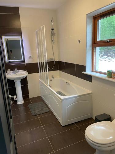 a bathroom with a tub and a sink and a toilet at Creevagh Cottage in Castlebar