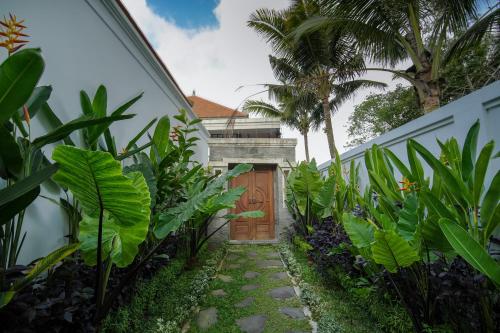 a garden path leading to a wooden door at Titian Dewi Private Villa Ubud - Close to Cretya Day Club in Tegalalang