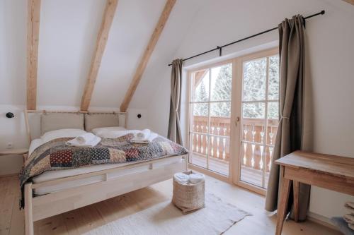 Srednja Vas v Bohinju的住宿－Lovely Cottage in a mountain wilderness of the National Park，一间卧室设有一张床和一个大窗户