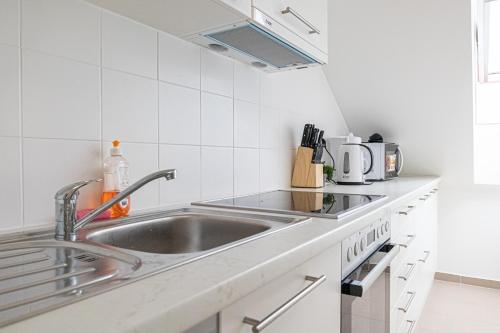 a kitchen with a sink and a counter at Airy Attic Apt.: Stylish Studio at Penzing Area in Vienna