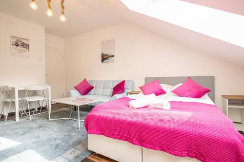 a bedroom with a large bed with pink sheets at Airy Attic Apt.: Stylish Studio at Penzing Area in Vienna