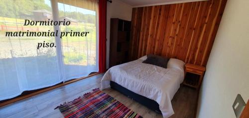 a bedroom with a bed and a large window at Casa Country Pucon in Villarrica