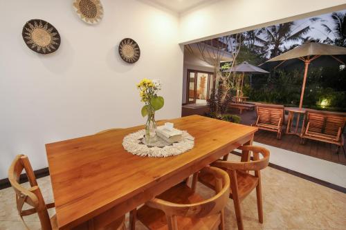 a dining room with a wooden table and chairs at Titian Dewi Private Villa Ubud - Close to Cretya Day Club in Tegalalang