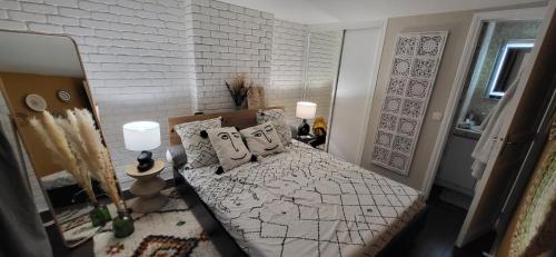een slaapkamer met een bed en een witte bakstenen muur bij Austerlitz Cocoon in Parijs