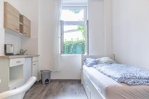 a small bedroom with a bed and a window at Brilliant 1BR Apt Comfortable Design/Near Schönbrunn in Vienna