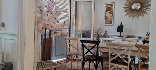- une salle à manger avec une table à manger et des chaises dans l'établissement Maison Berckoise Belle Époque - Plage et Centre, à Berck-sur-Mer