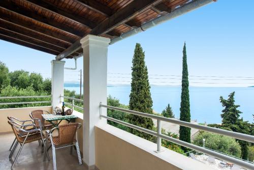 balcón con mesa, sillas y vistas al océano en Hotel Barbati Sea View B&B en Barbati