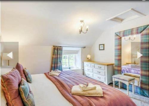 a bedroom with a bed and a dresser and a mirror at Stone Cottage, Idyllic Village in Ingham