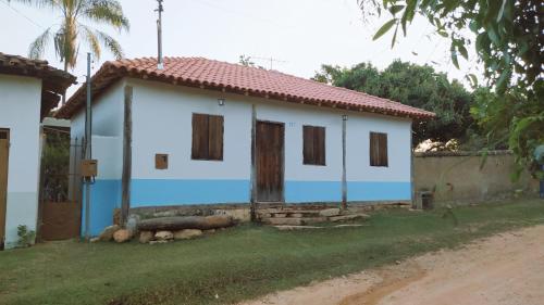 a blue and white house with a dirt road at Casa Rustica Milho Verde in Milho Verde