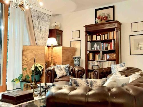 un soggiorno con divano e libreria di La Villa Bianca - appartamento in villa a Sesto Fiorentino