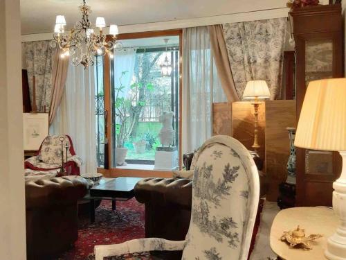 un soggiorno con divano, tavolo e finestra di La Villa Bianca - appartamento in villa a Sesto Fiorentino