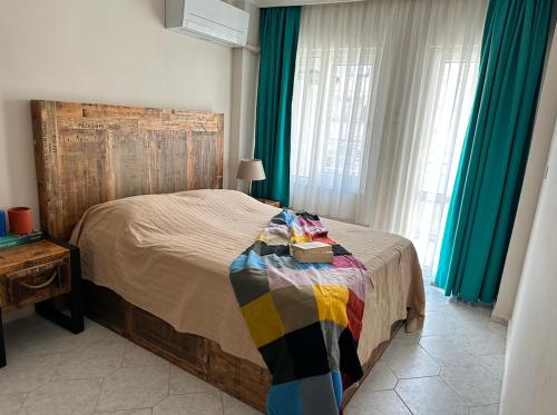 een slaapkamer met een bed met een houten hoofdeinde bij Merkeze Yakın, Ev Rahatlığında in Marmaris