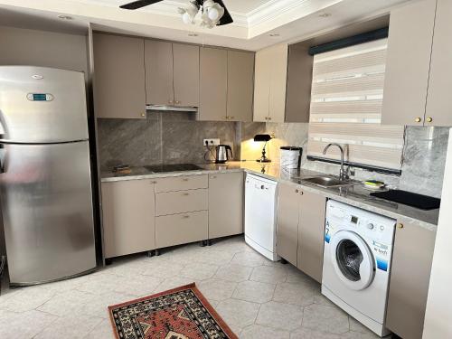 a kitchen with a refrigerator and a washer and dryer at Merkeze Yakın, Ev Rahatlığında in Marmaris