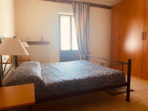 - une chambre avec un lit doté d'une couette bleue et d'une fenêtre dans l'établissement AGRITURISMO CASCINA MONACHE, à Santa Vittoria dʼAlba