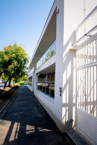 a white building with a shadow on the side of it at Elixír Panzió in Nyírbátor